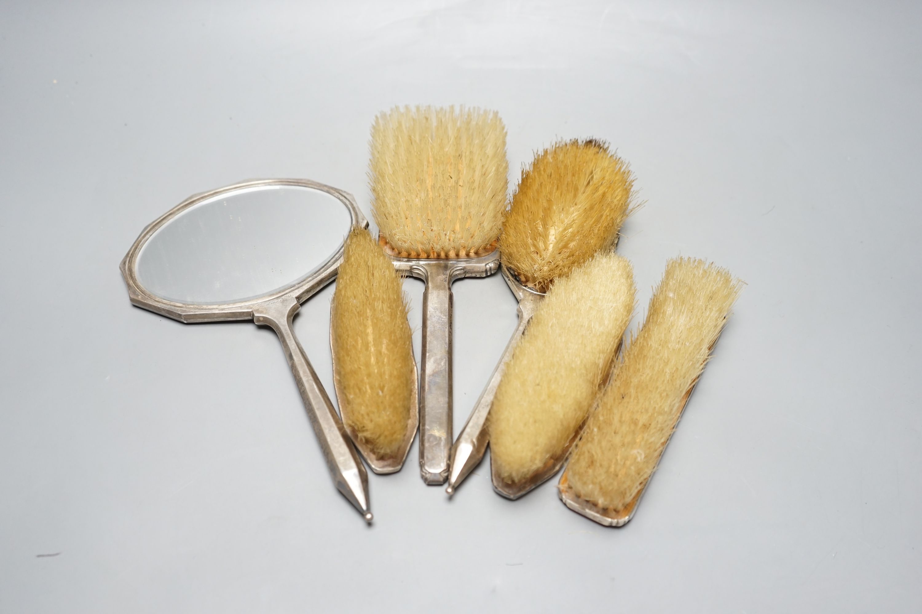 Two 1950's silver and enamel mounted brushes and an earlier four piece silver mounted brush set.